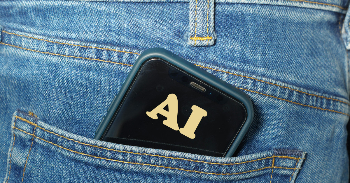 Smartphone with 'AI' on the screen in the back pocket of a pair of jeans